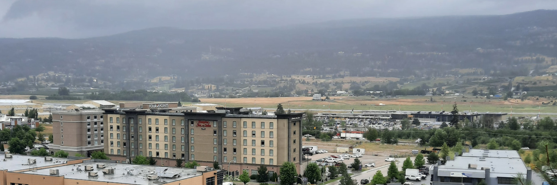 A completely unrelated picture of some mountains in Kelowna with a hotel in the foreground